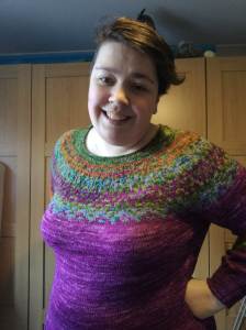 A person wearing a colourwork yoke sweater angled slightly away from the camera